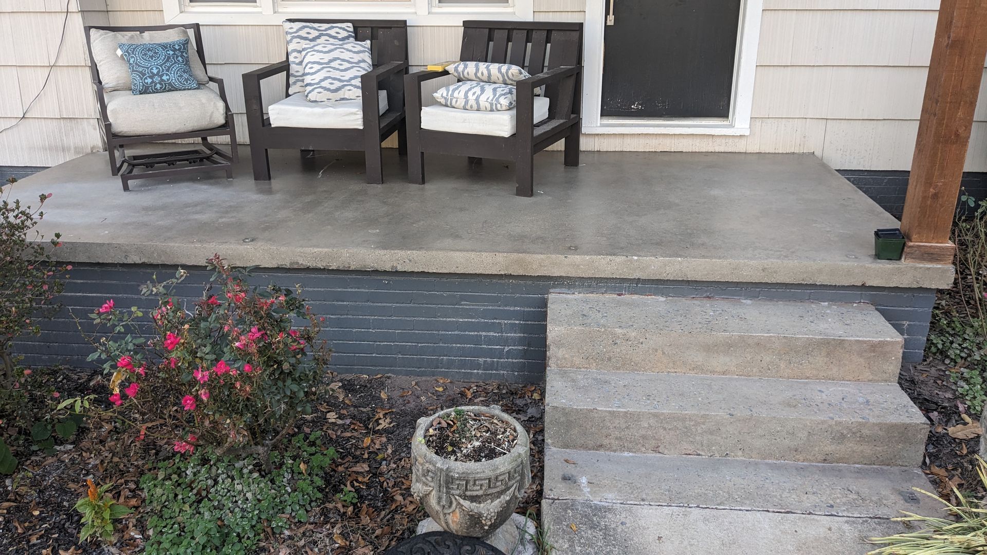 A porch with two chairs and a table on it