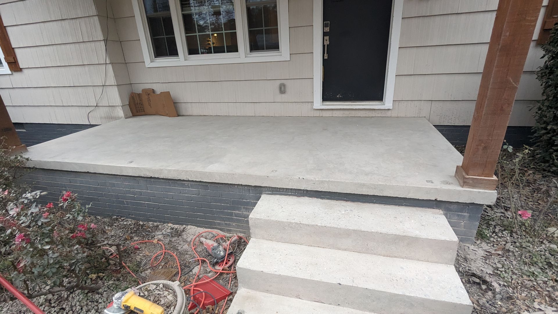 A concrete porch with steps leading to the front door of a house.