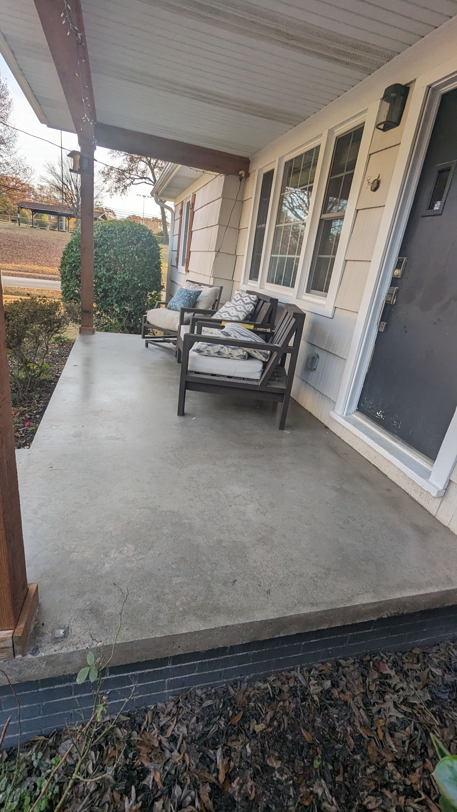 There is a porch with a couch and chairs on it.