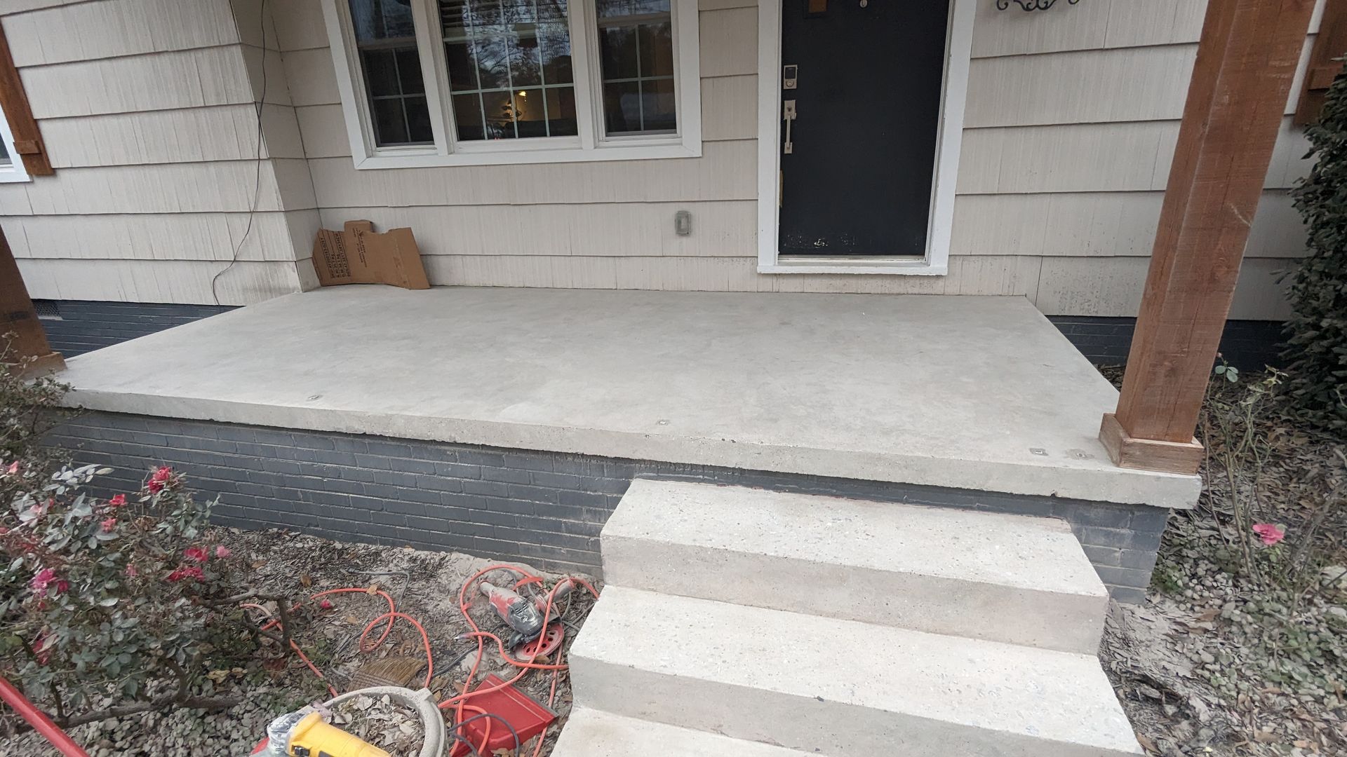 A concrete porch with steps leading to the front door of a house