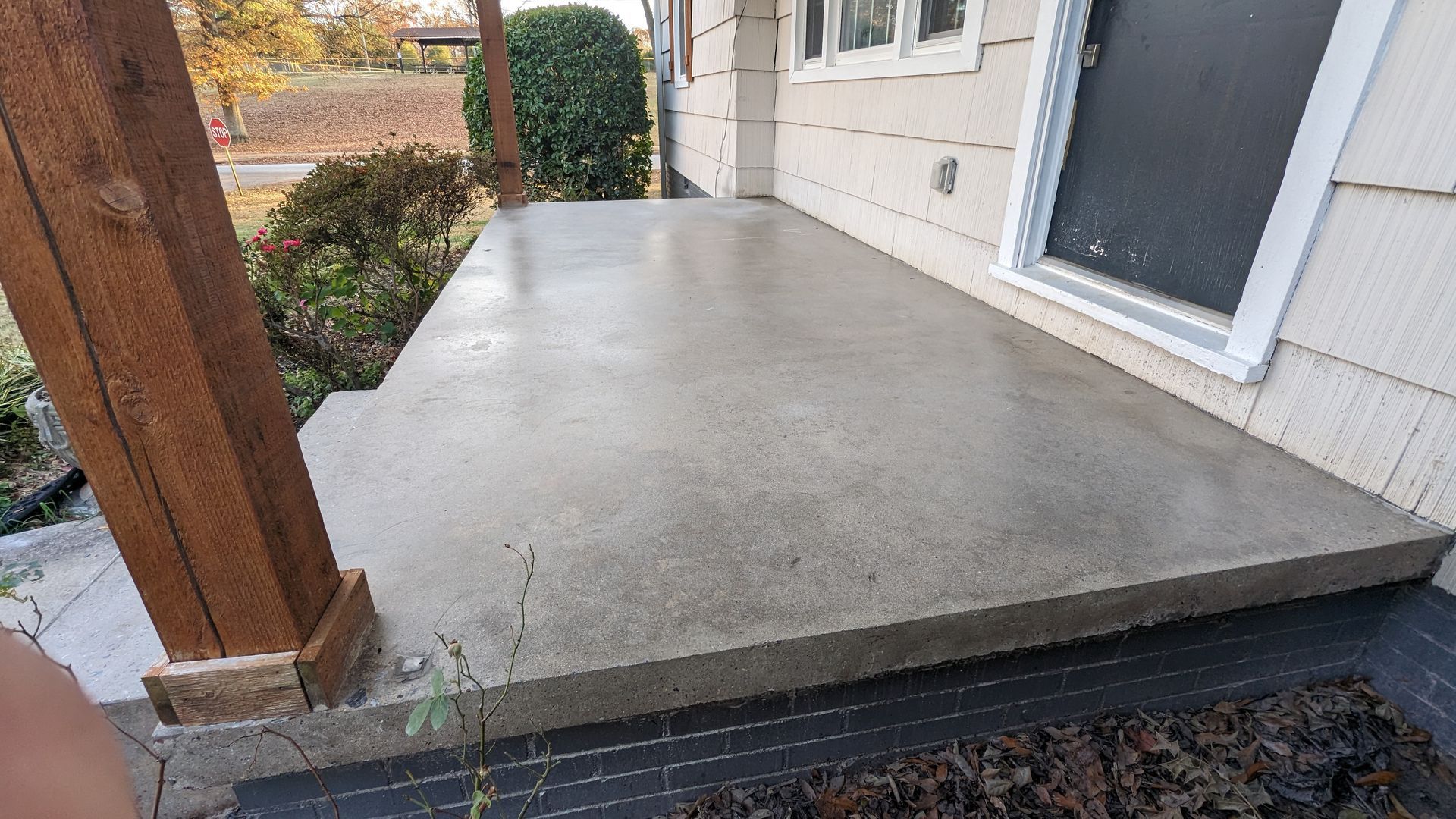 A concrete porch is being built on the side of a house.