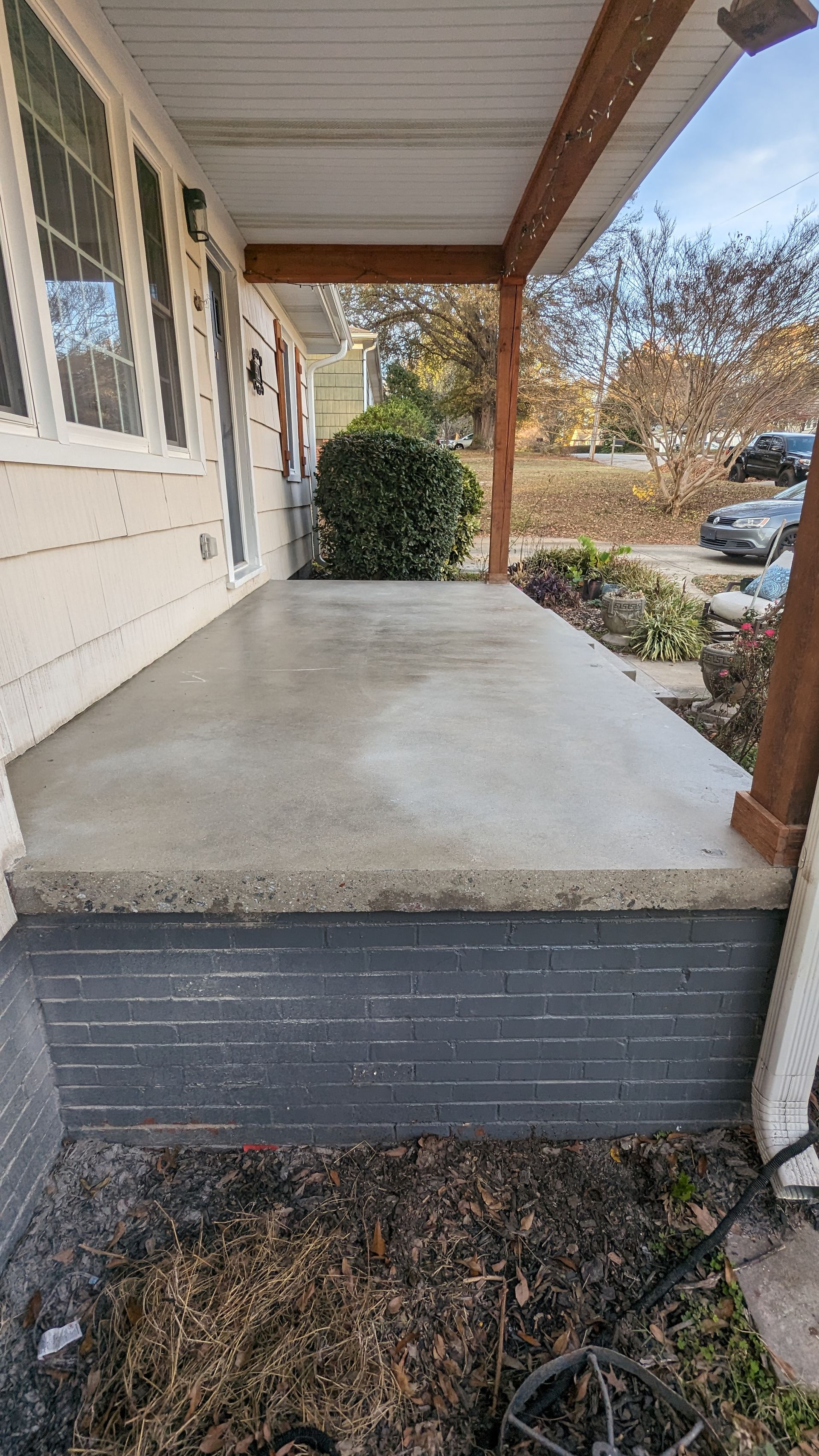 A concrete porch on the side of a house.