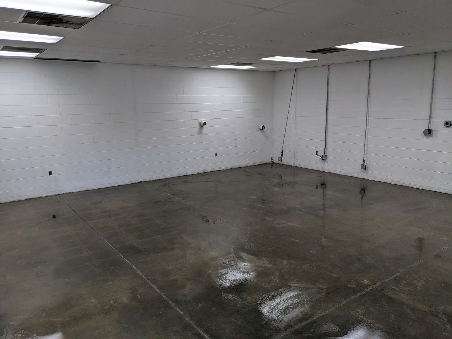 An empty room with a concrete floor and white walls.