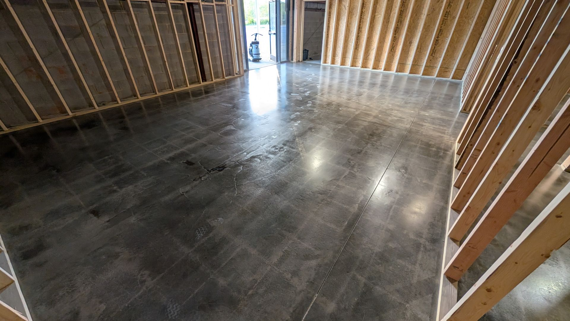 An empty room with a concrete floor and wooden walls