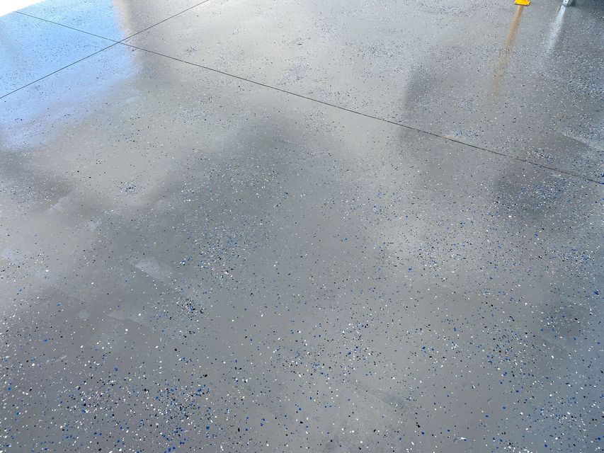 A gray floor with a lot of small dots on it