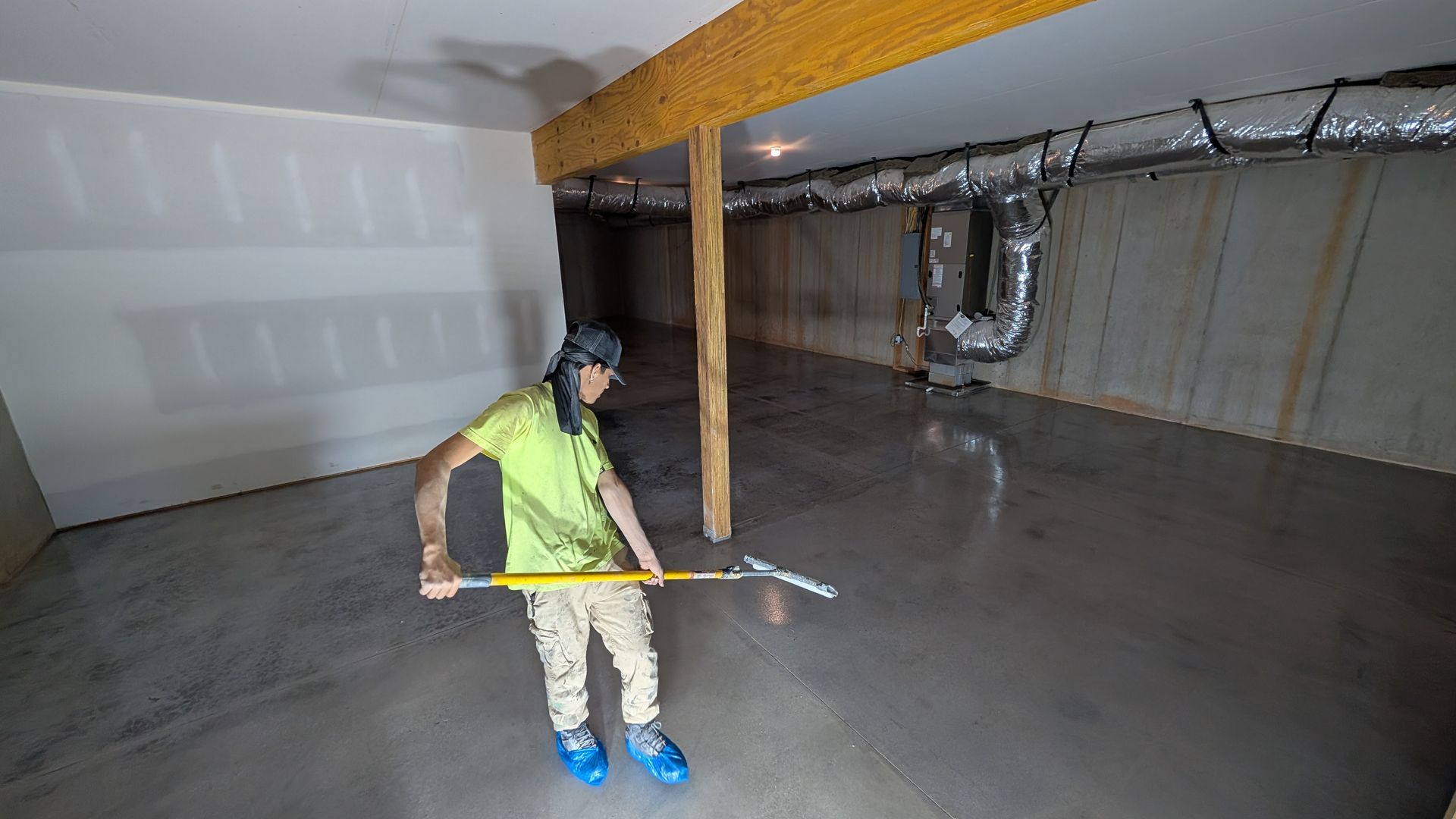 Worker applying grind and seal on basement floor installed by Zachary Daniel Concrete in Pickens, SC.