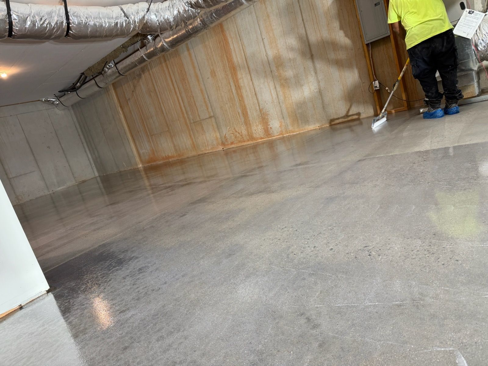 Freshly sealed concrete floor under ductwork installed by Zachary Daniel Concrete in Powdersville, SC.