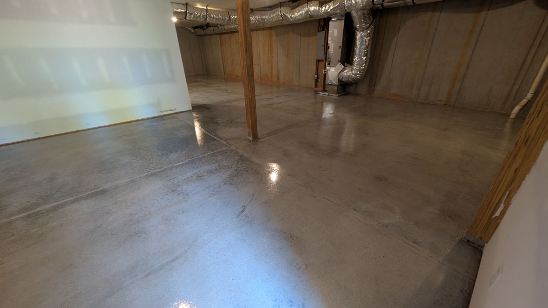 Shiny concrete floor sealed in HVAC-ready basement installed by Zachary Daniel Concrete in Central, SC.