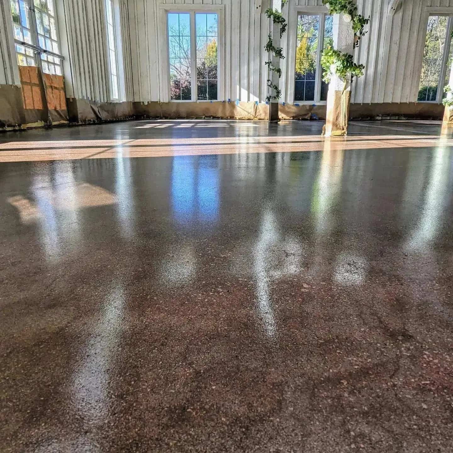 A large room with a shiny concrete floor and a lot of windows.