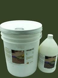 A bucket and a gallon of liquid are sitting next to each other on a green background.
