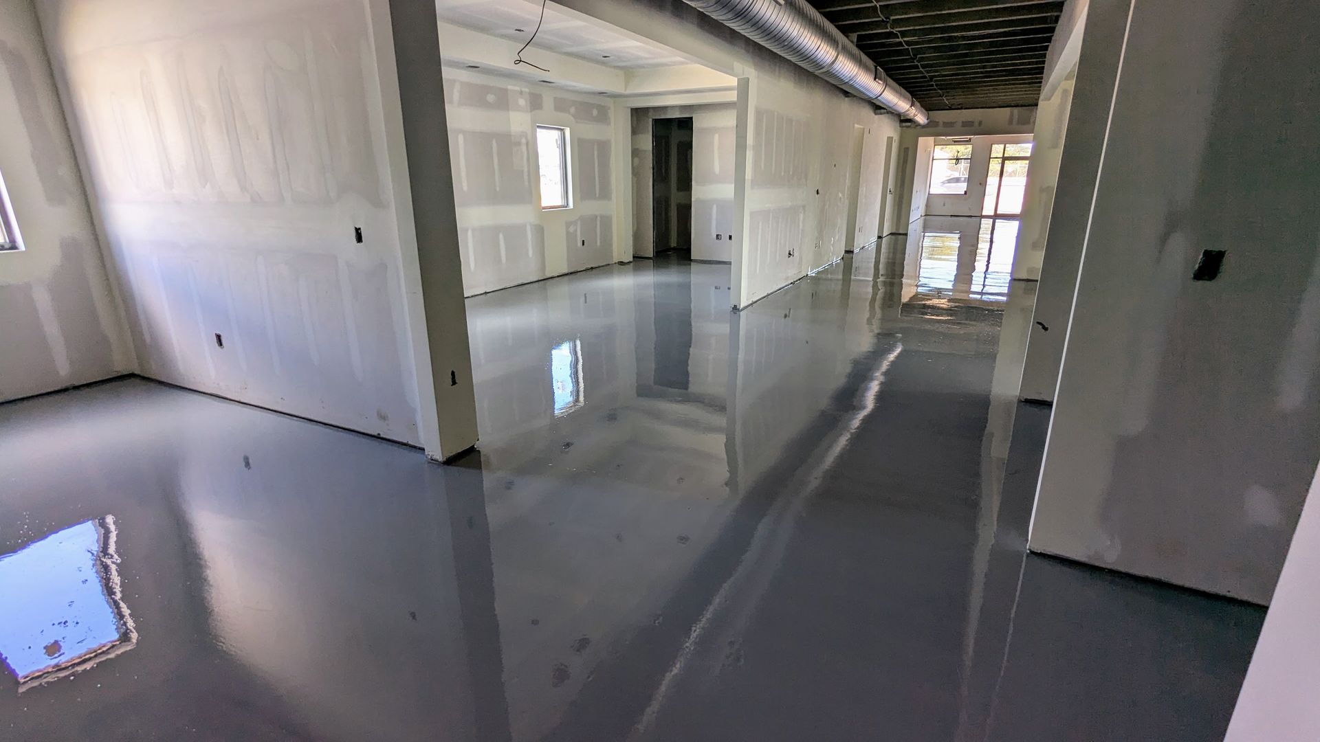 A large empty room with a shiny floor and white walls.