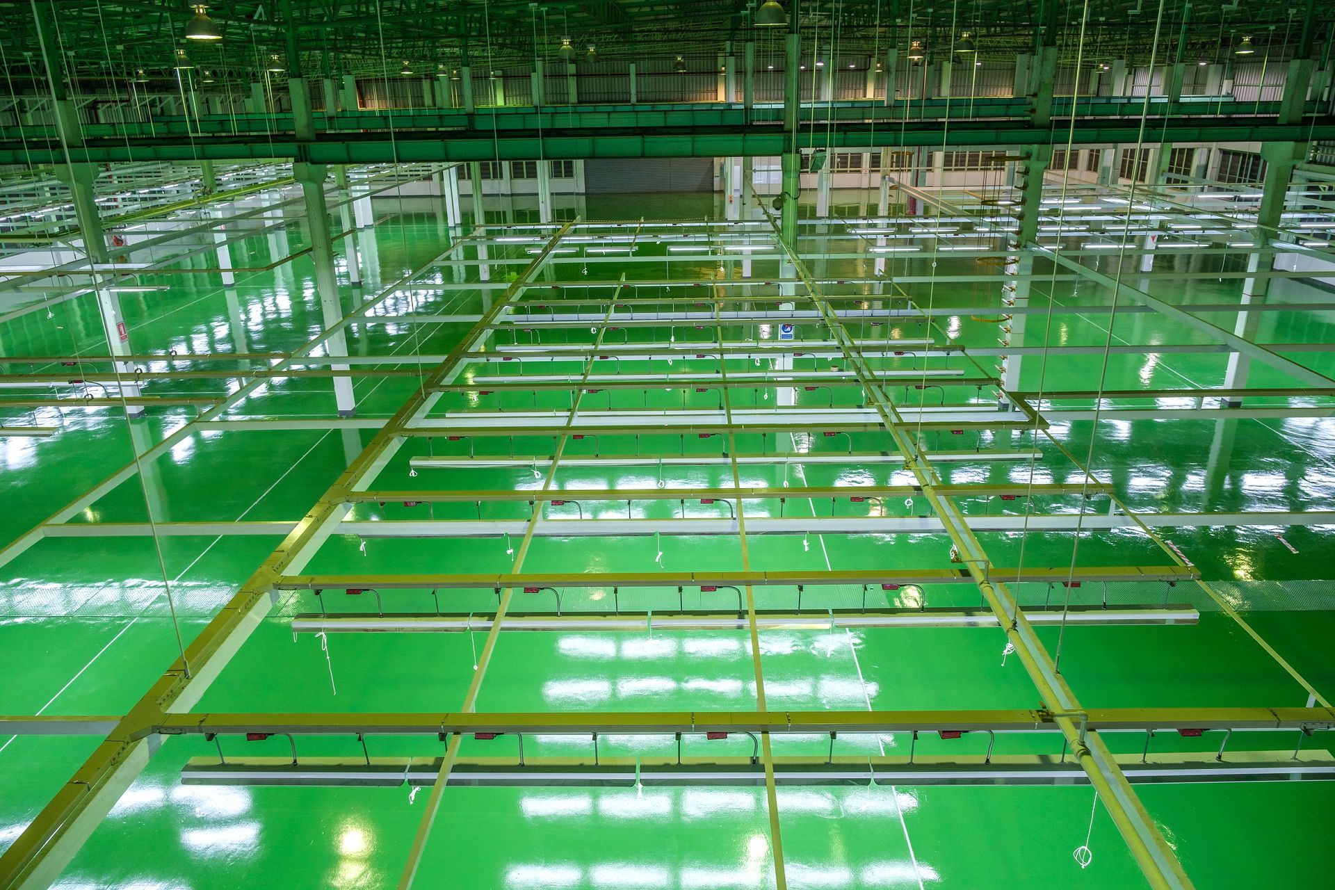 Looking up at the ceiling of a large building with green floors.