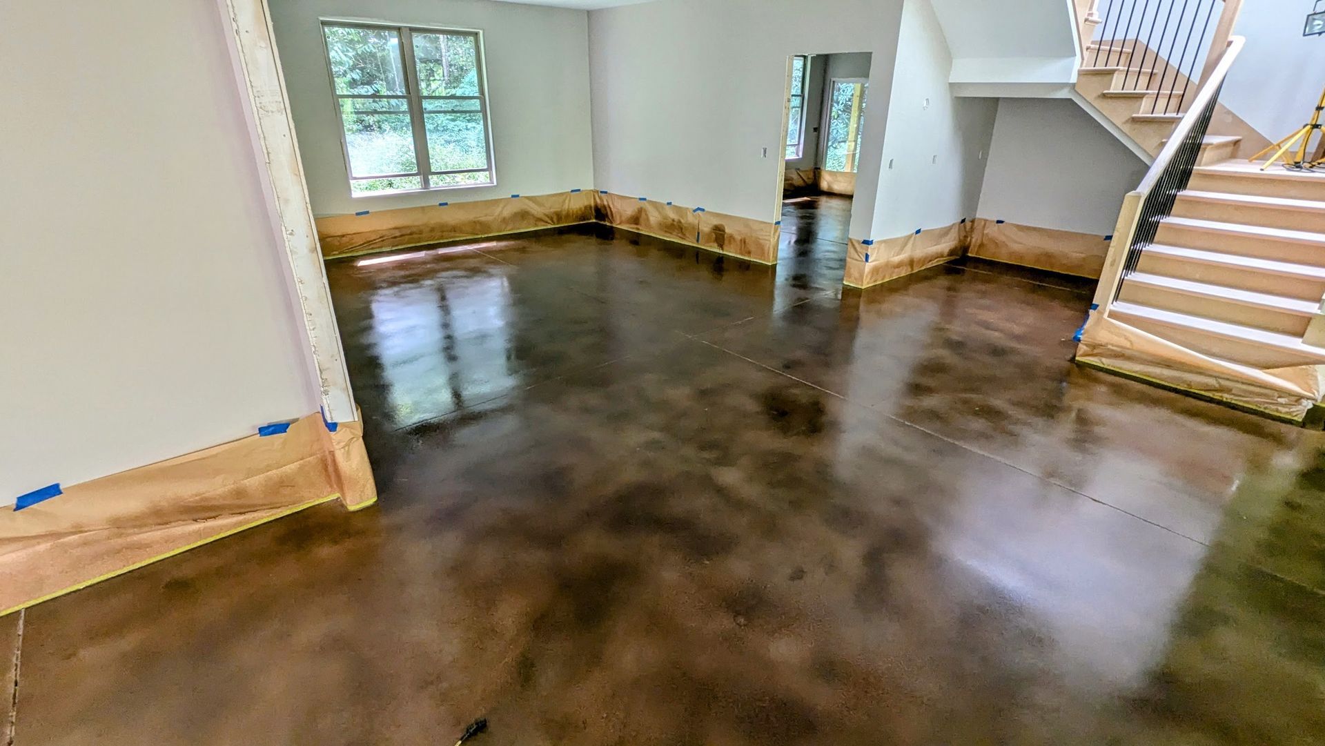 A living room with a concrete floor and stairs.