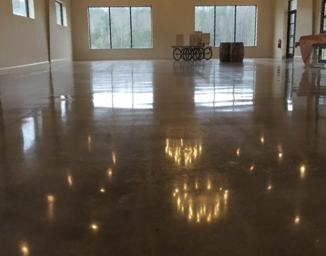 A large room with a shiny concrete floor and lots of windows.