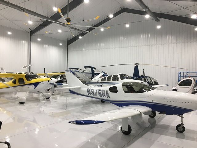 A blue and white plane with n375ra on the side is parked in a hangar.