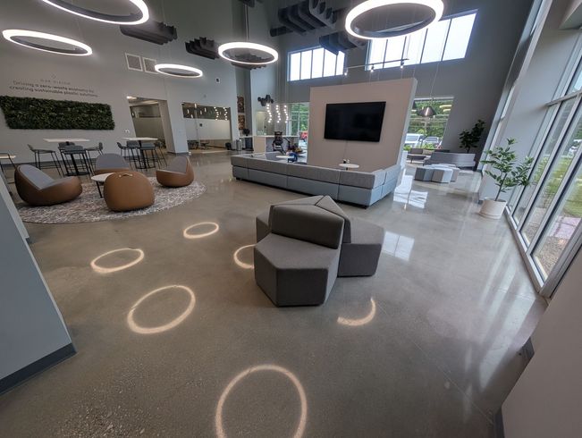 A close up of a shiny concrete floor with lights reflected in it.