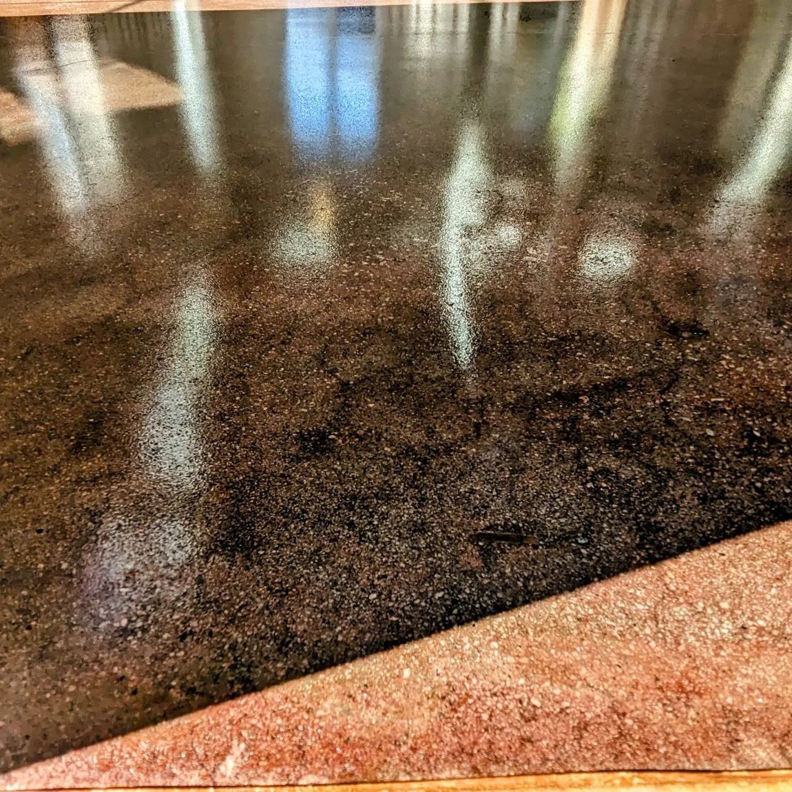 A close up of a marble counter top with a reflection of a window.