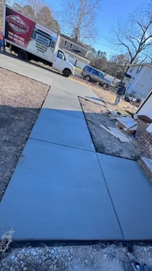A concrete walkway is being built next to a truck.