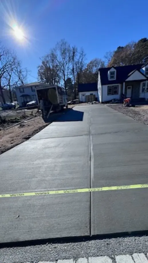 A concrete driveway is being built in front of a house.