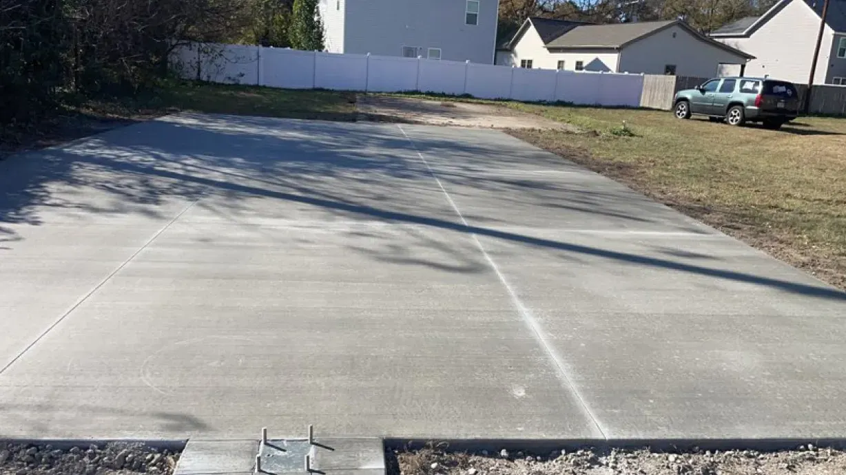 A concrete driveway is being built in front of a house.