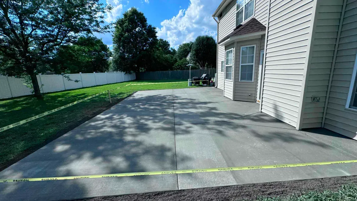 A concrete driveway is being built in front of a house.