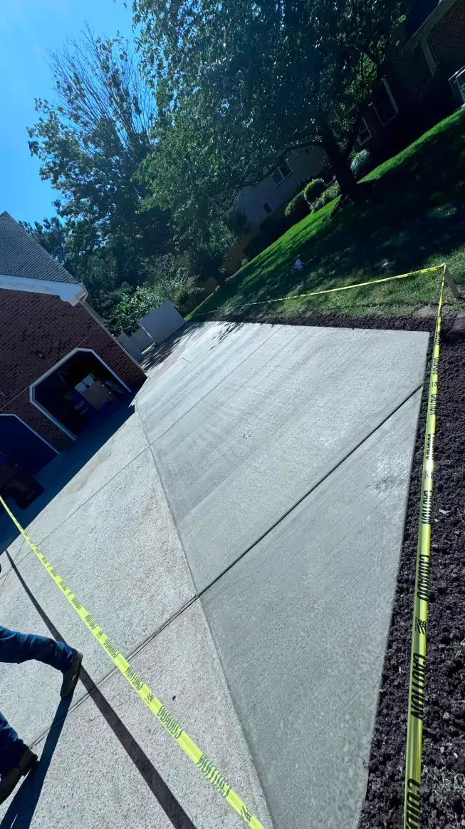 A concrete driveway is being built in front of a house.