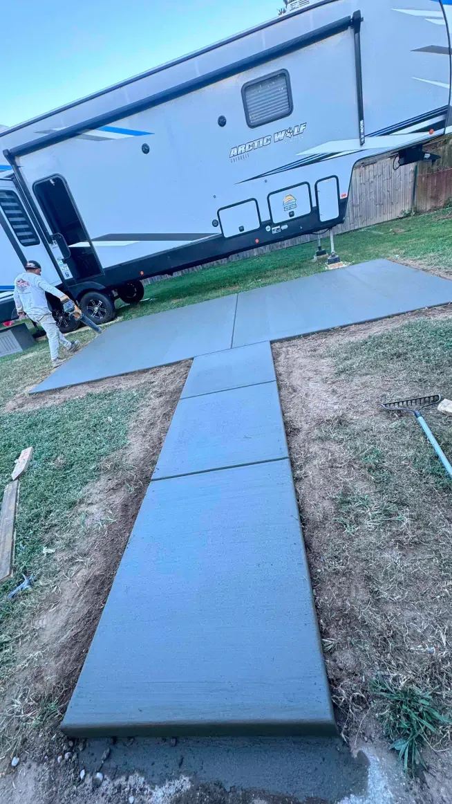 A concrete walkway is being built in front of a trailer.