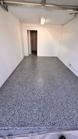 A garage with a gray floor and white walls.