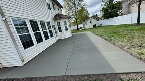 A large white house with a concrete walkway in front of it.
