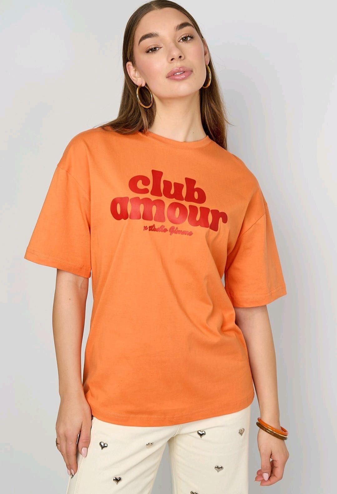 Een persoon draagt ​​een oranje T-shirt met de tekst 