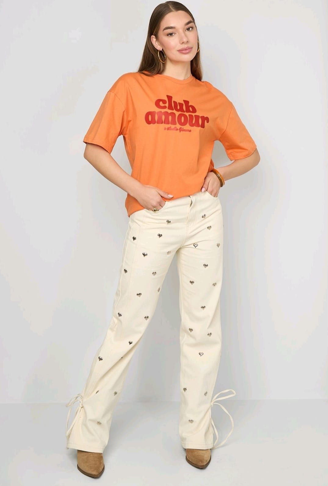 Een persoon draagt ​​een oranje T-shirt met de tekst 