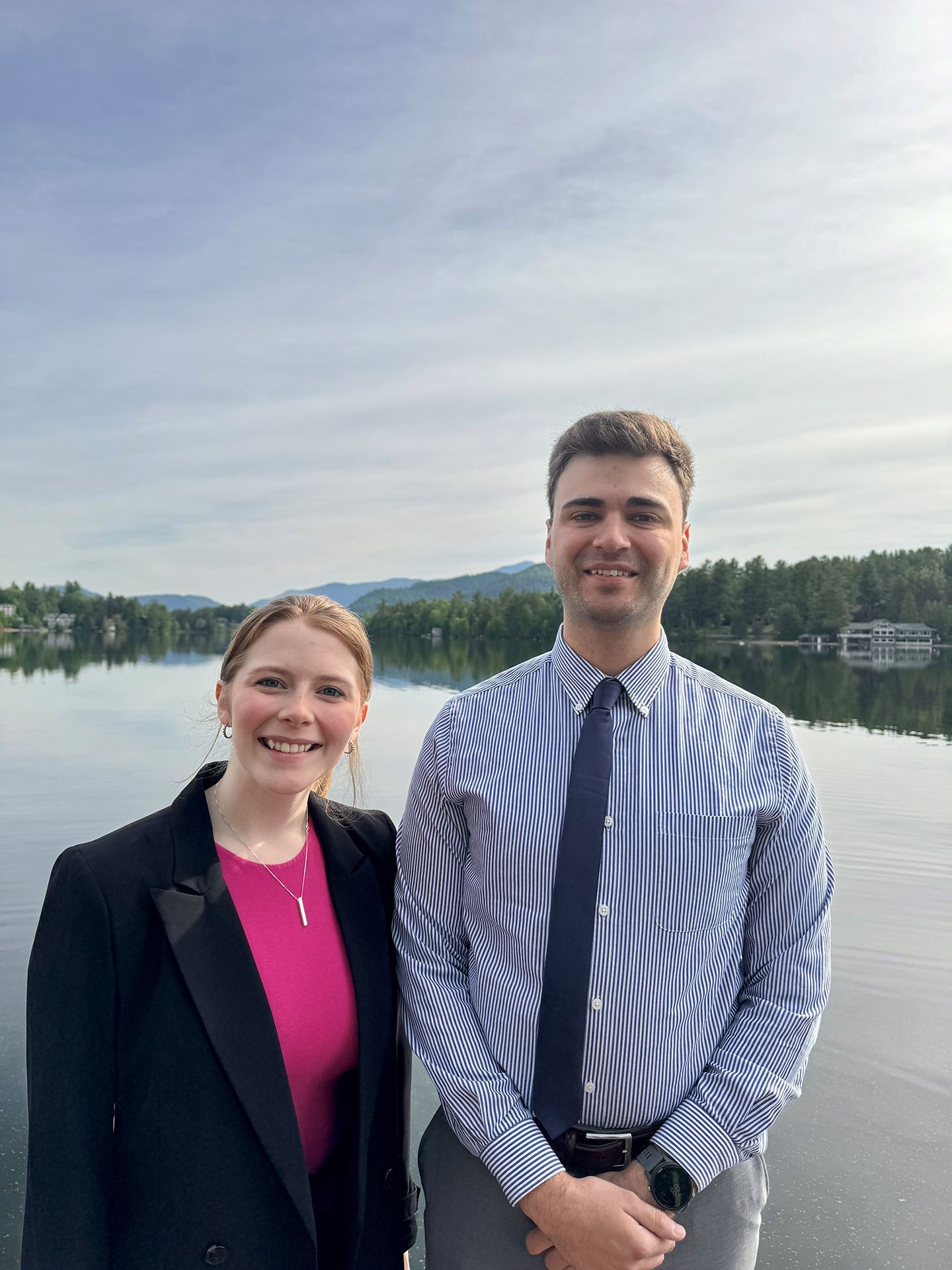 Attorney Elliot J Vanier and Law Clerk Madison Marshall both at Flink Maswick Law posing in front of the Mirror Lake in Lake Placid NY. 