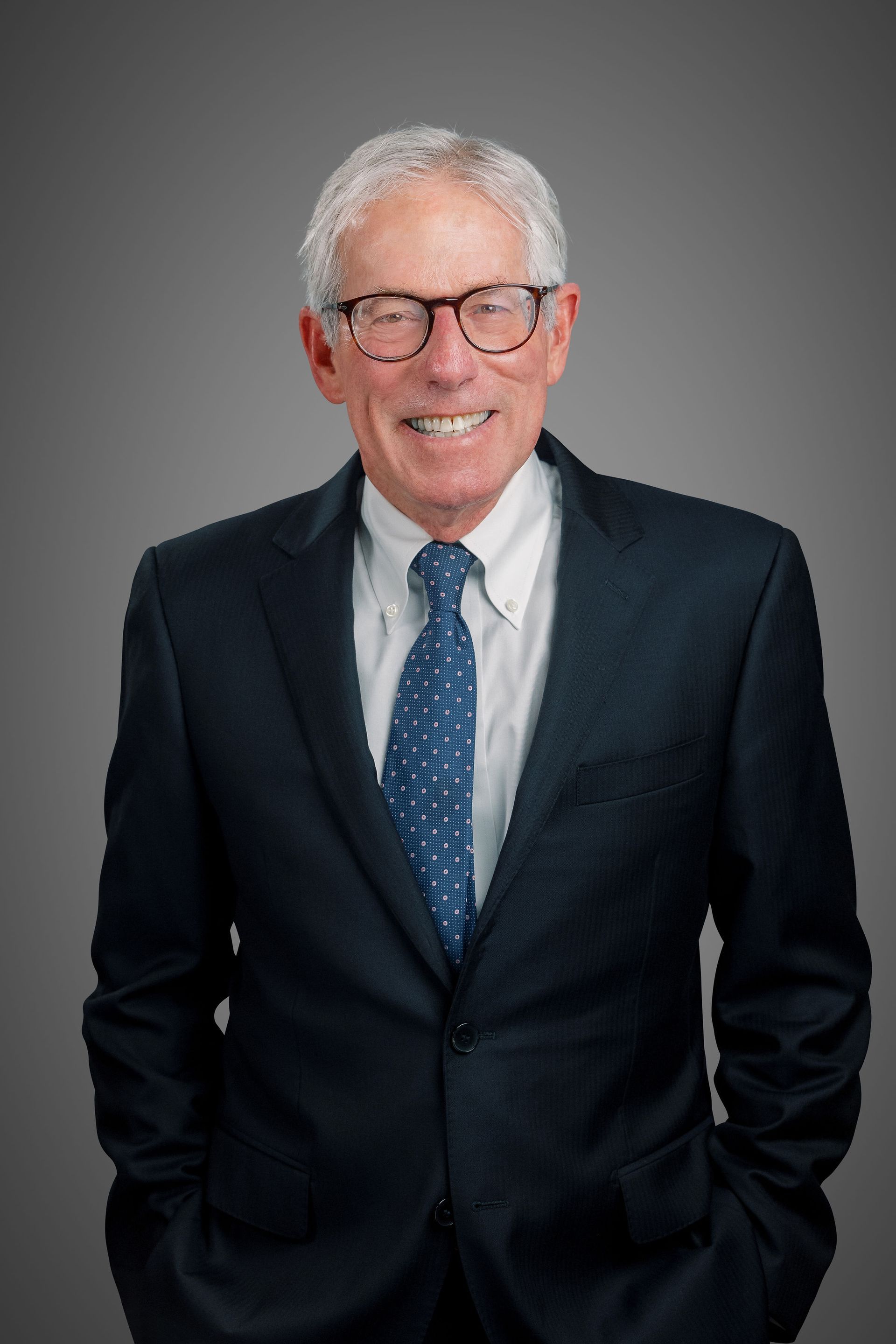 Ed Flink, Super Lawyer, in a suit and tie, smiling with his hands in his pockets.