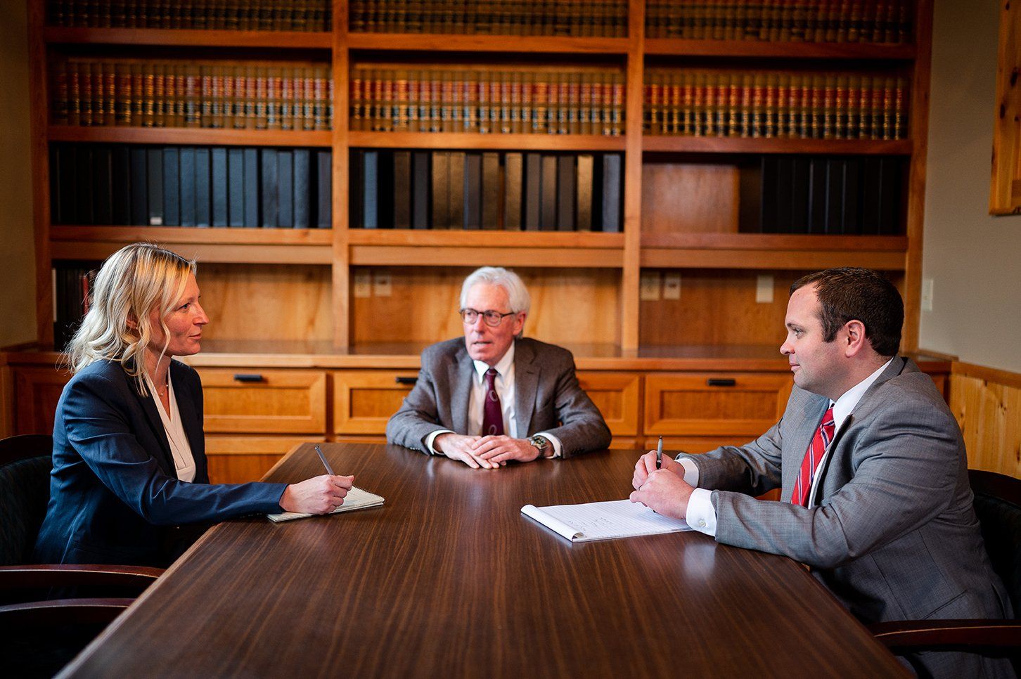 Attorneys Katherine Giovacco, Ed Flink, and James Maswick of Flink Maswick Law PLLC at conference table.