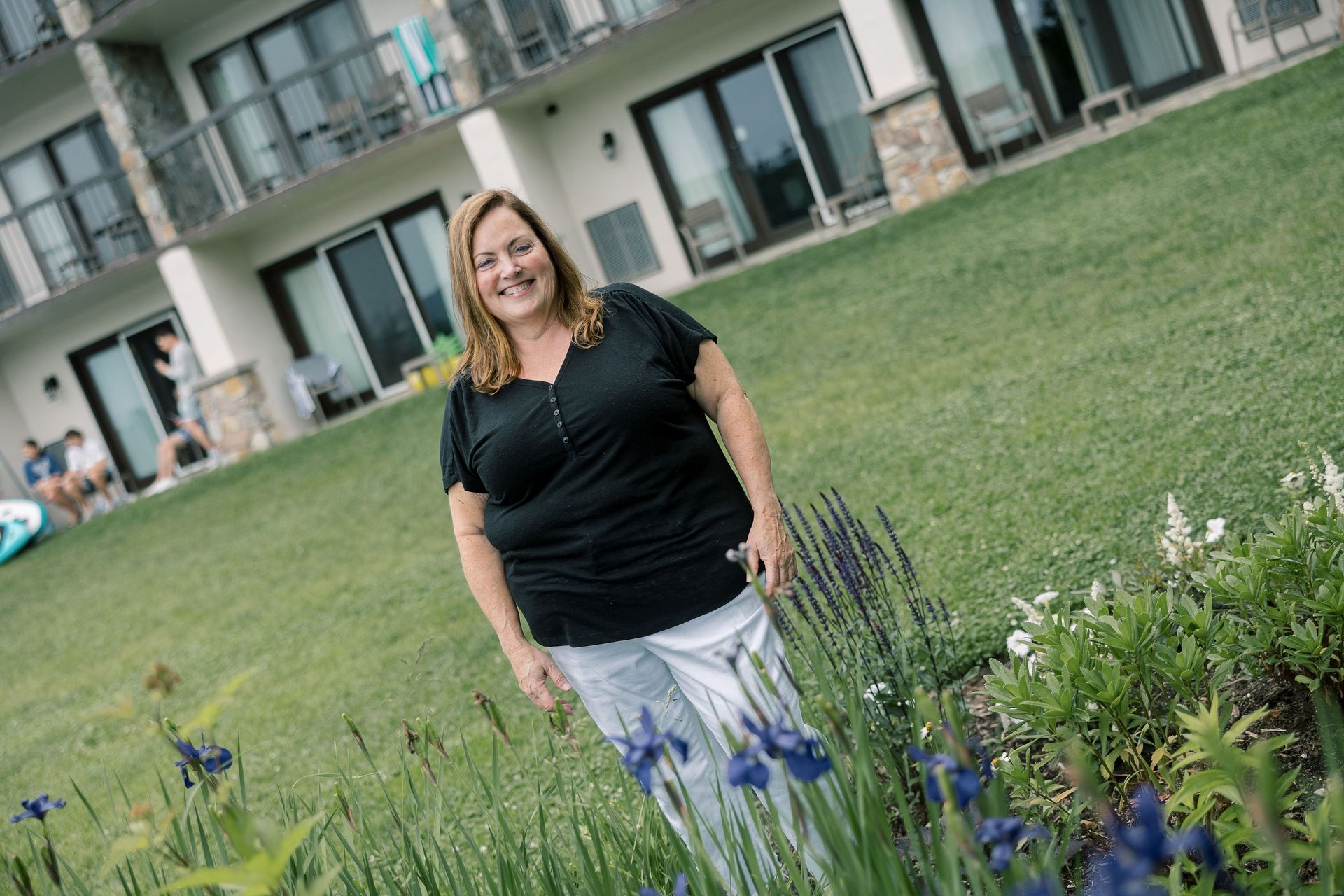 Attorney Jill O'Sullivan is standing near a flower bed in Lake Placid, NY.