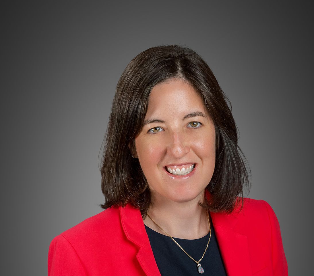 Attorney Molly Hann in a red suit jacket and black blouse.