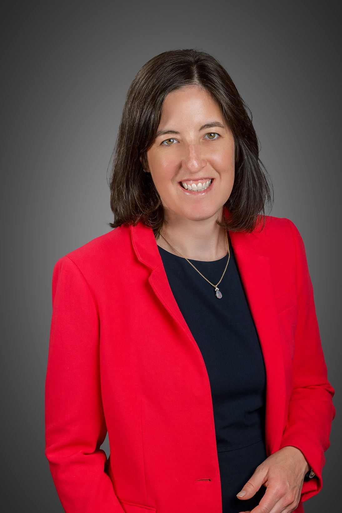 Attorney Molly Hann wearing a red suit jacket and black blouse.