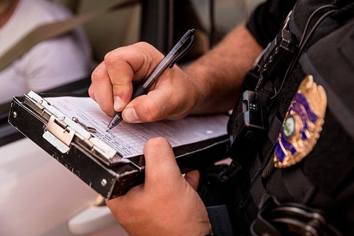 Policeman writing a ticket.