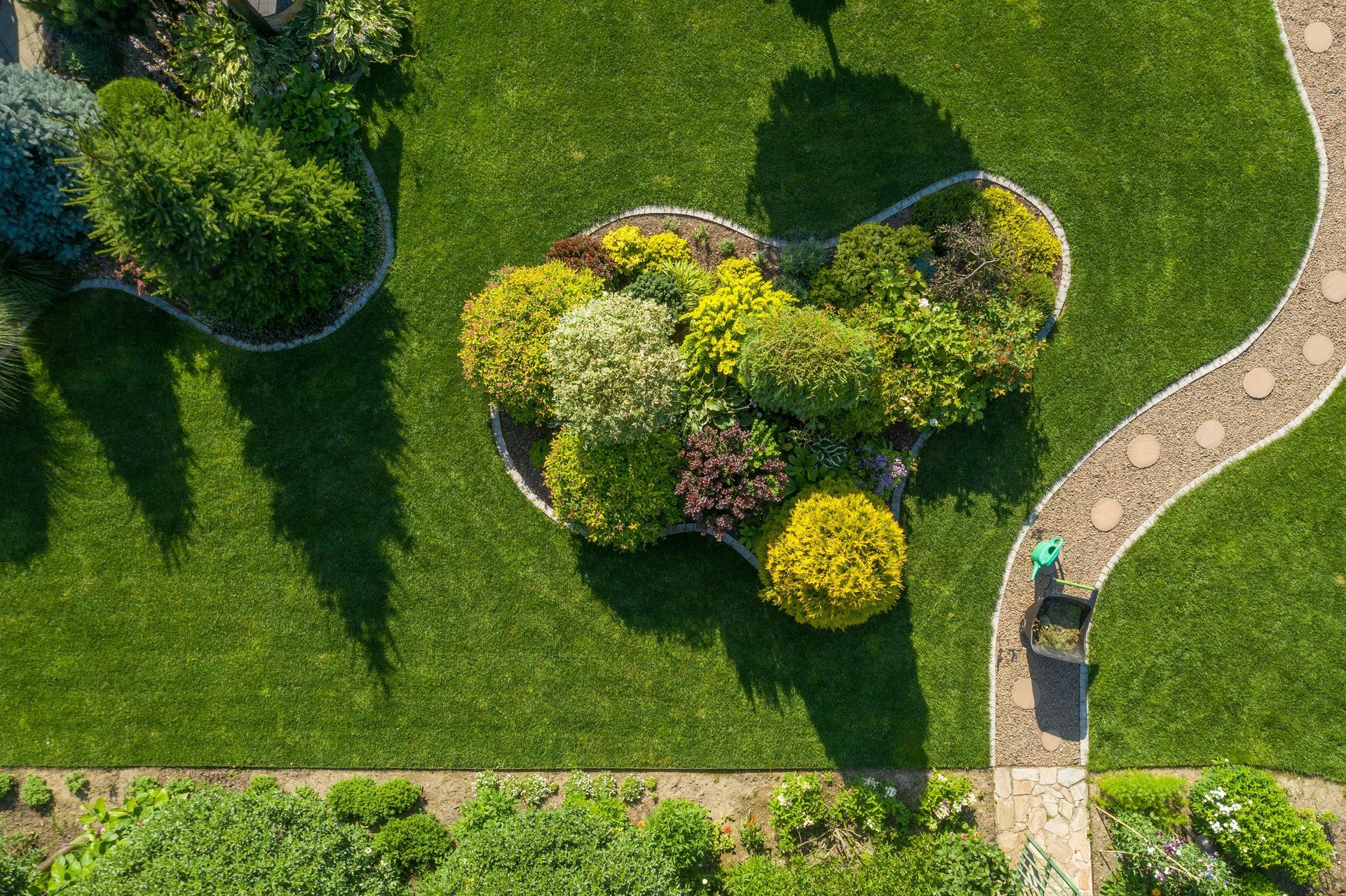 an aerial view of a garden with a path and lots of plants .