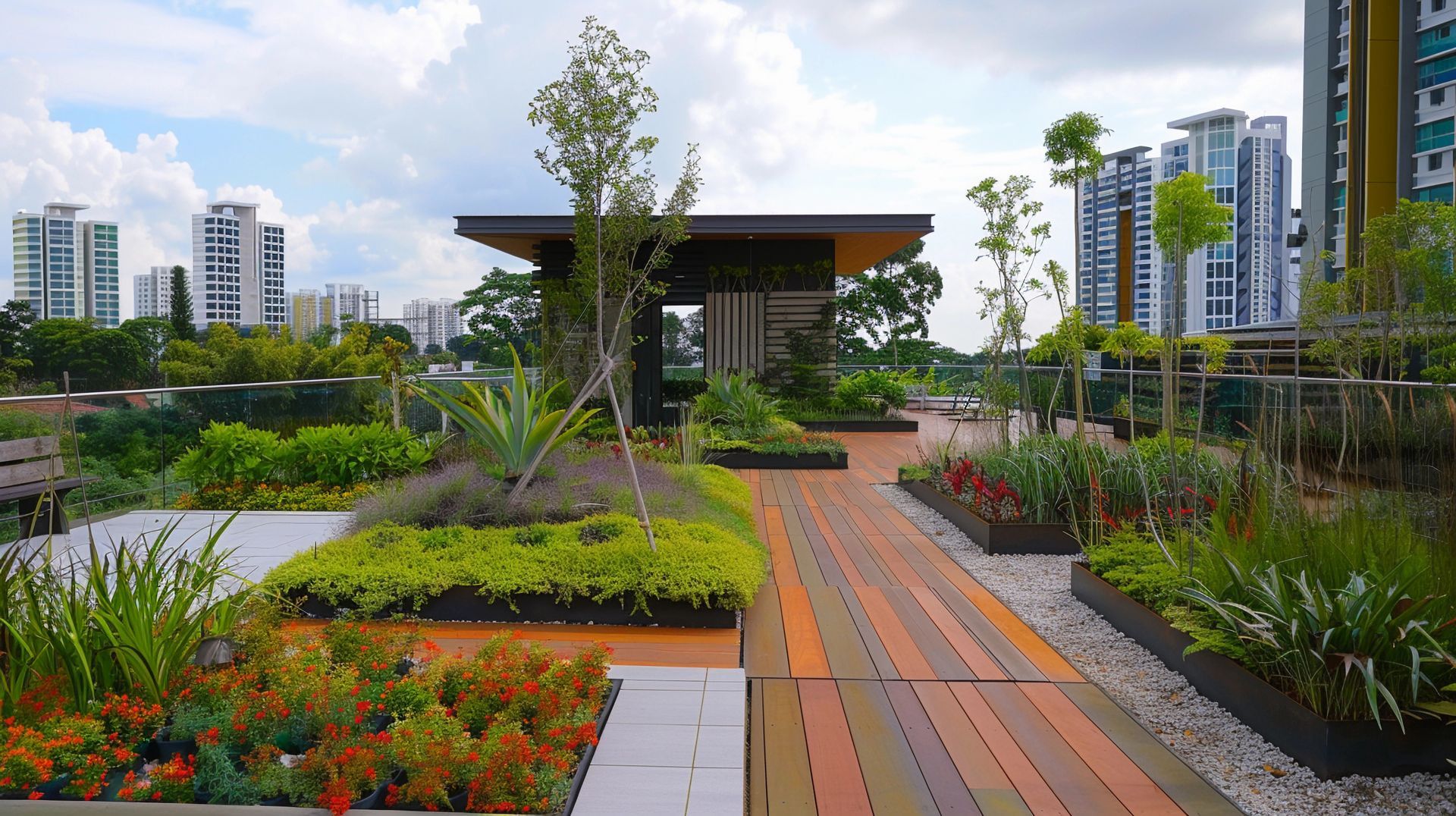 Rooftop garden with wooden walkway, greenery, and buildings in the background under a cloudy sky.