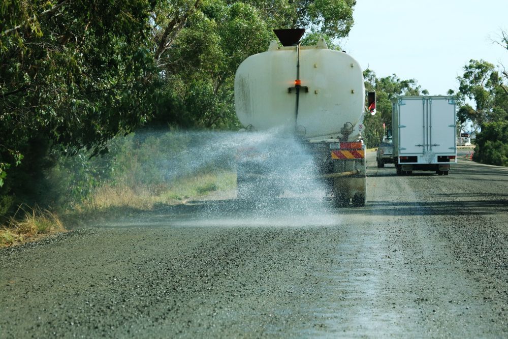 Tanker Truck Spraying Water on a Gravel Road to Suppress Dust — AGM HIRE NQ in Kirwan, QLD