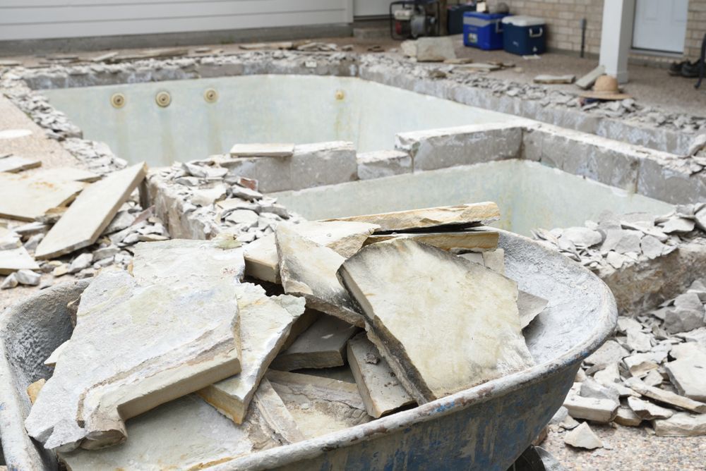 Wheelbarrow Filled With Stone Pieces, Pool Renovation — AGM HIRE NQ in Kelso, QLD