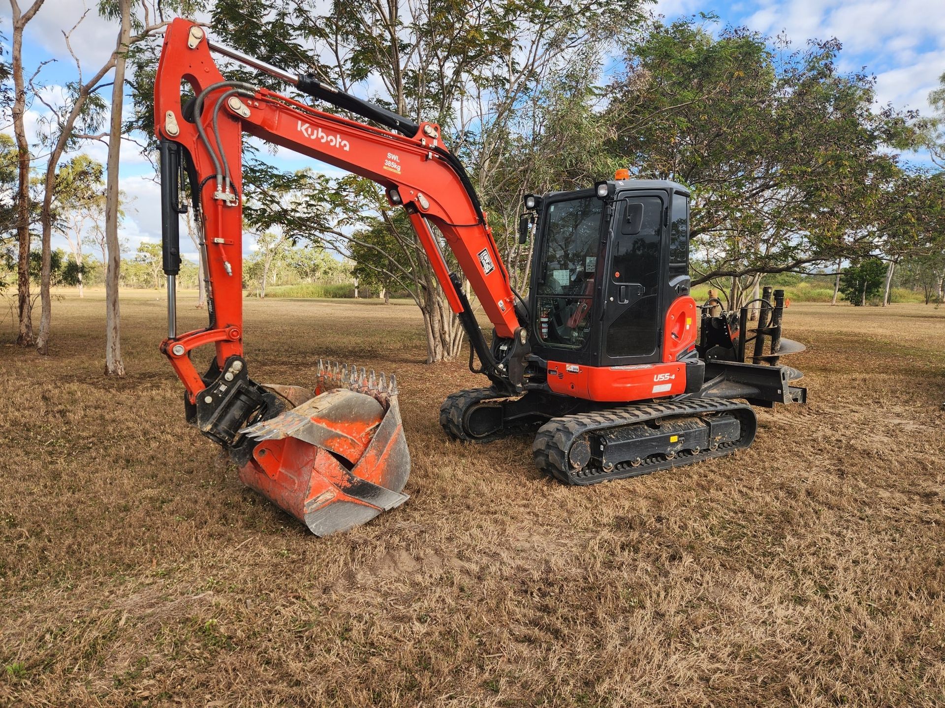 Red Kubota Excavator Digging on Brown Grass Field — AGM HIRE NQ in Kelso, QLD