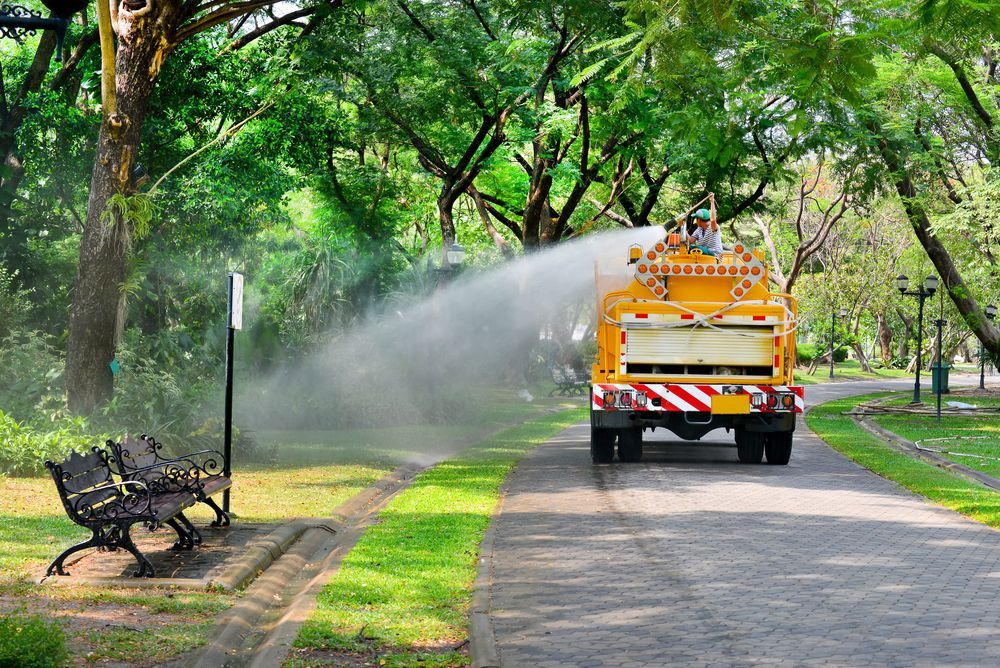 Yellow Water Truck Spraying Water in a Park — AGM HIRE NQ in Condon, QLD