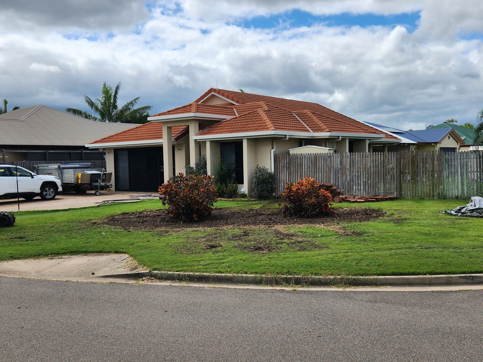 House With Red Tile Roof, Light Beige Walls, and a Wooden Fence — AGM HIRE NQ in Kirwan, QLD