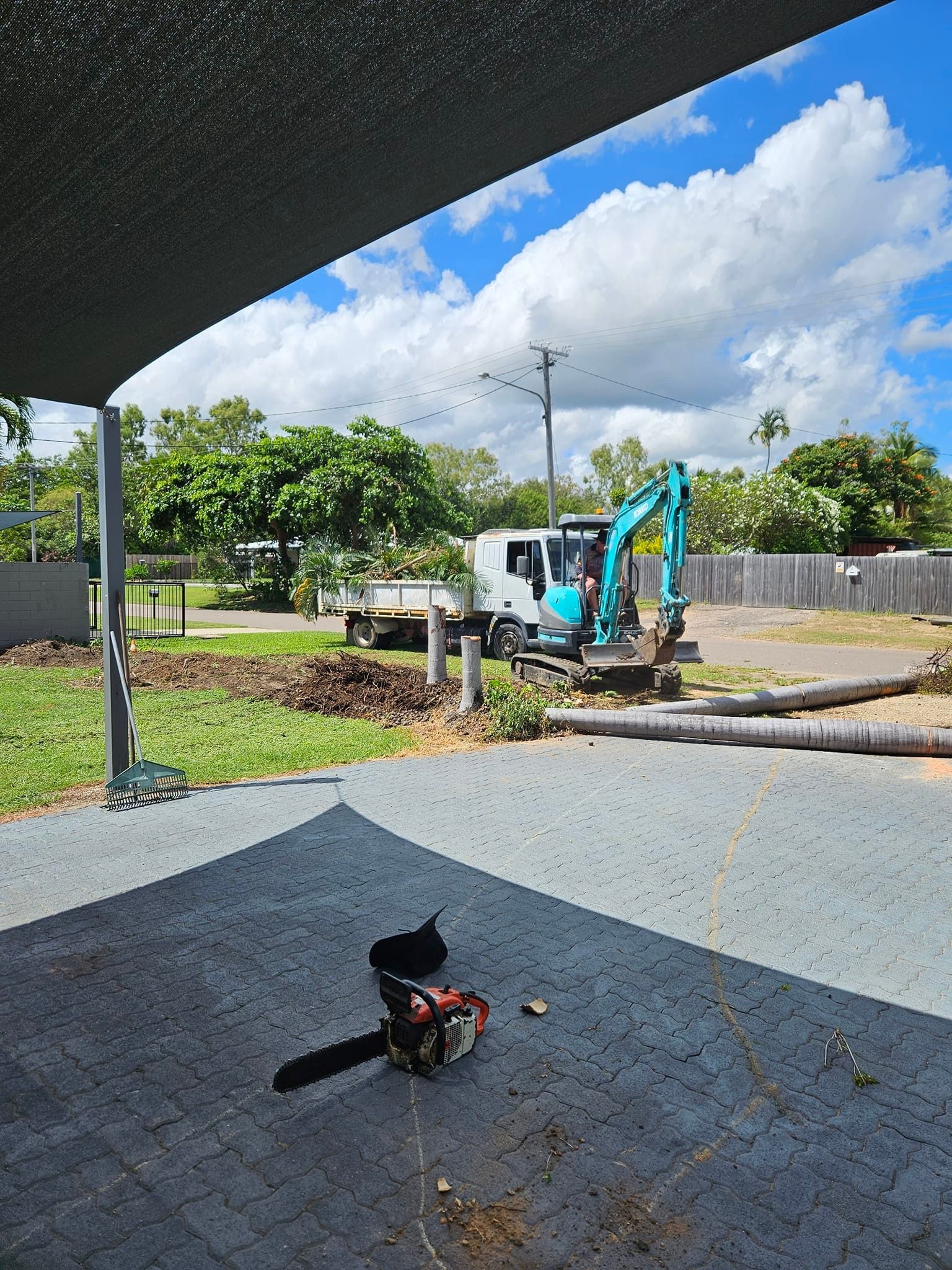 Chainsaw on Patio; Excavator and Truck in the Background — AGM HIRE NQ in Condon, QLD