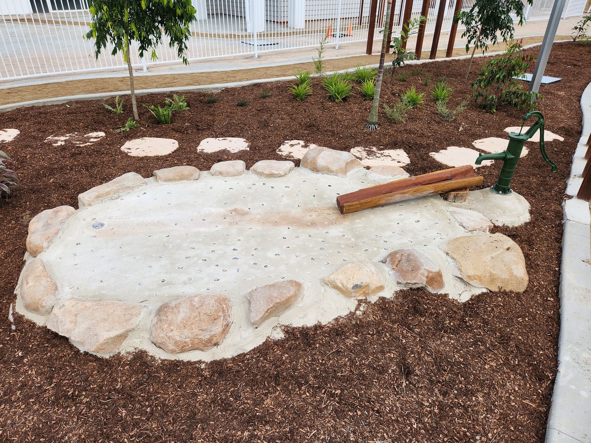 A Small Sand Pit Edged With Rocks, With a Water Pump — AGM HIRE NQ in Condon, QLD
