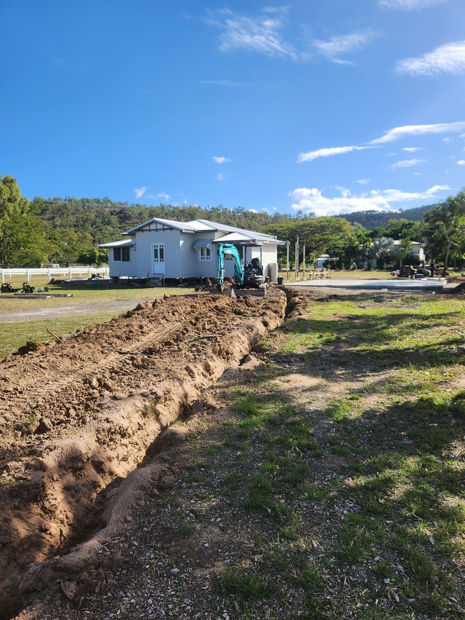 A Trench Dug in Grassy Field With a Backhoe — AGM HIRE NQ in Condon, QLD