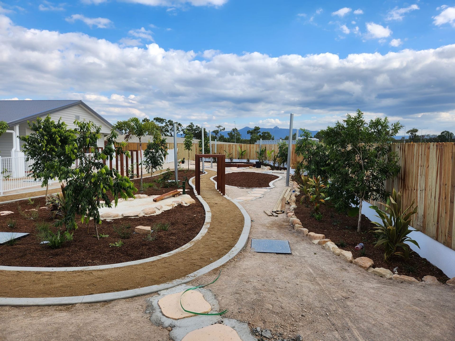 A Garden Path Leading Into a Backyard With Trees — AGM HIRE NQ in Condon, QLD