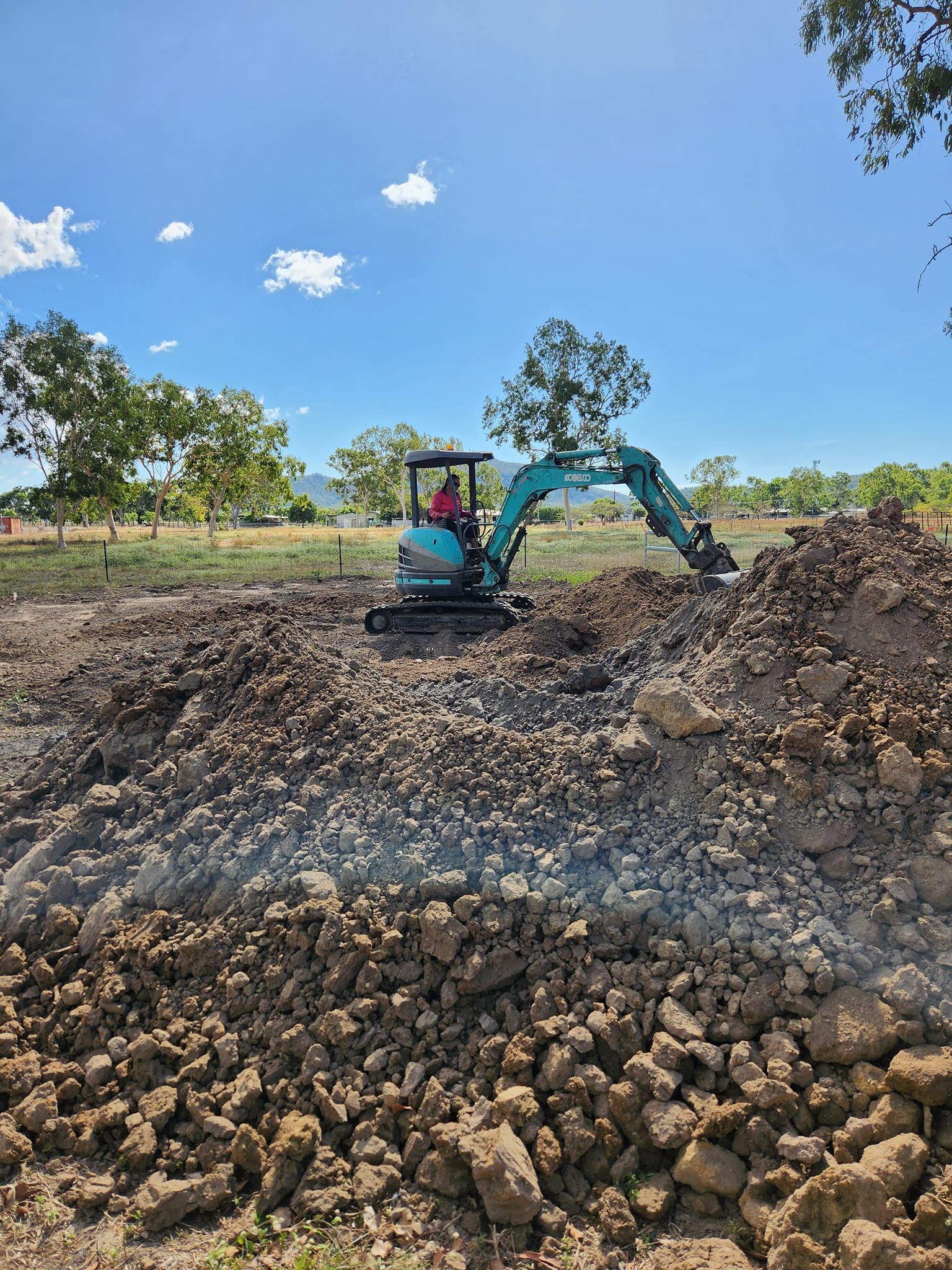 Small Blue Excavator Gathered Some Demolished Rocks — AGM HIRE NQ in Kirwan, QLD